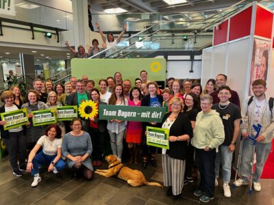 Dutzende schwäbische Grüne mit Haltern: Sonnenblumen-Logo und Schriftzug "Team Bayern - mit dir"